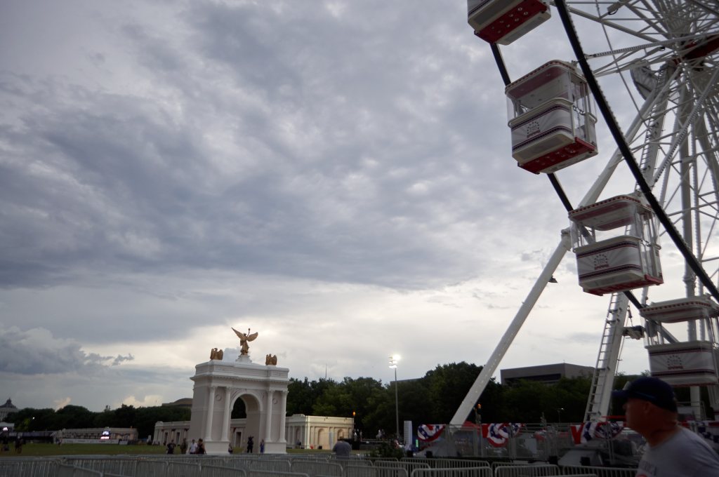 Empty Ferris wheel and arch mock-up under storm clouds