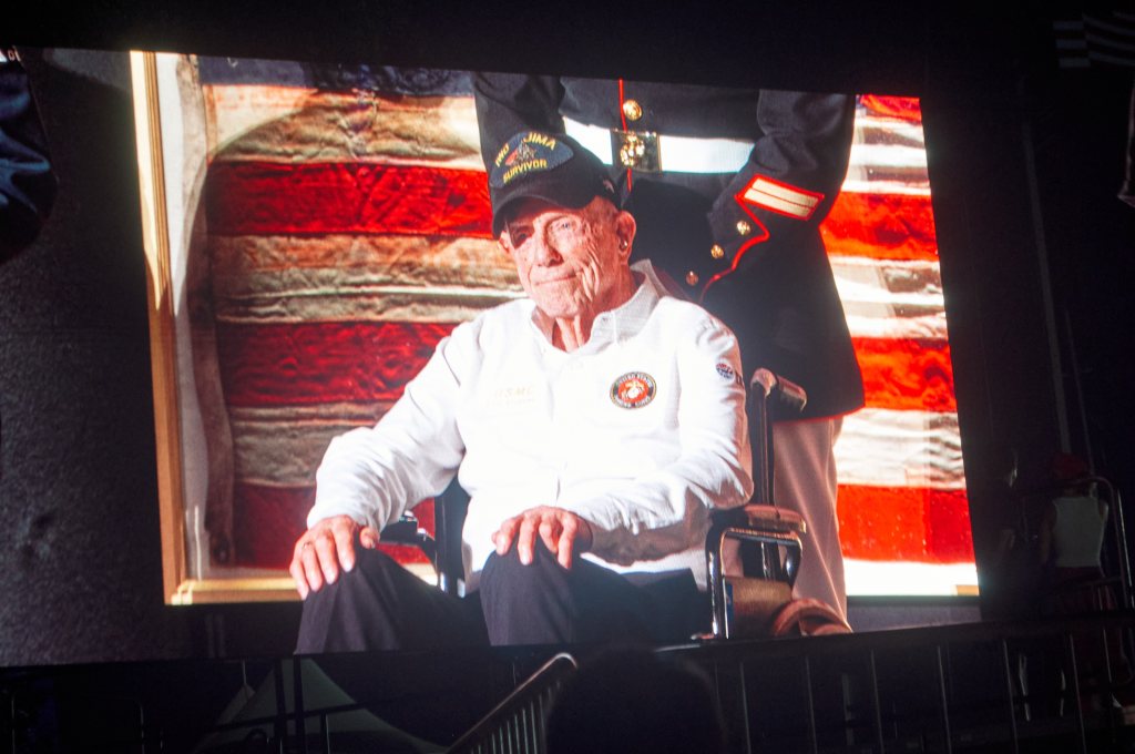Video screen showing a veteran in an Iwo Jima Survivor cap