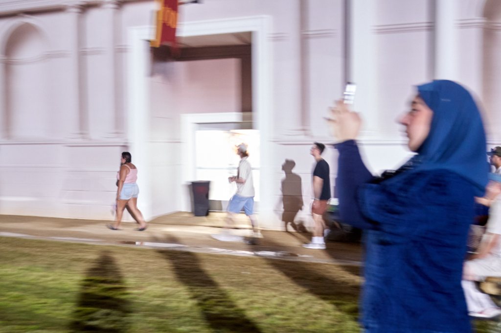 Woman in a headscarf taking a photo with her phone