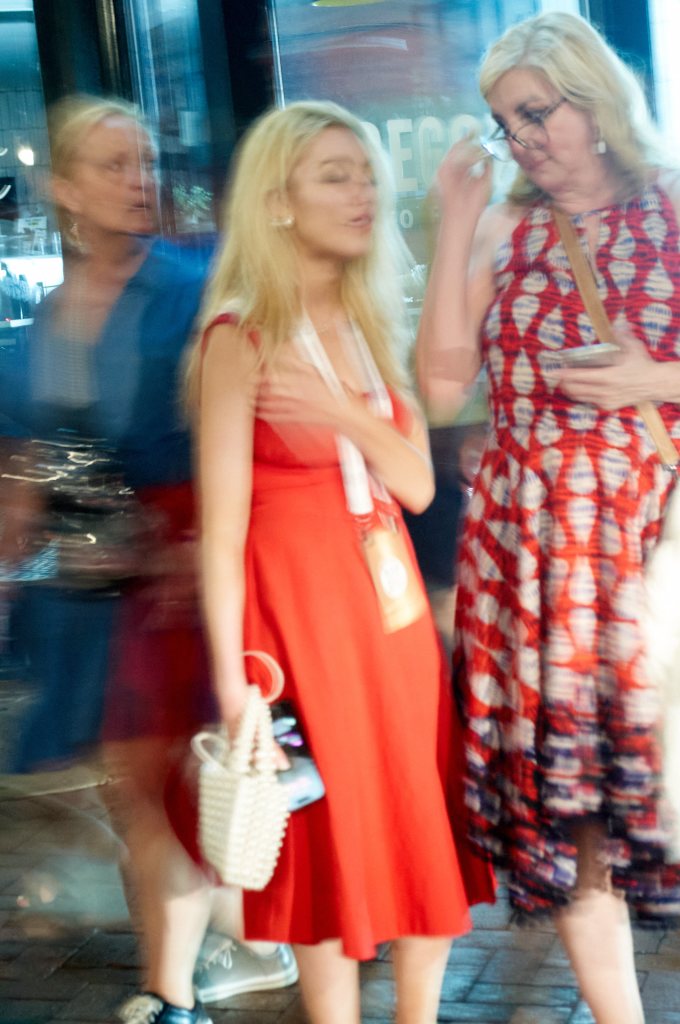 Women in red walking at night, motion blur