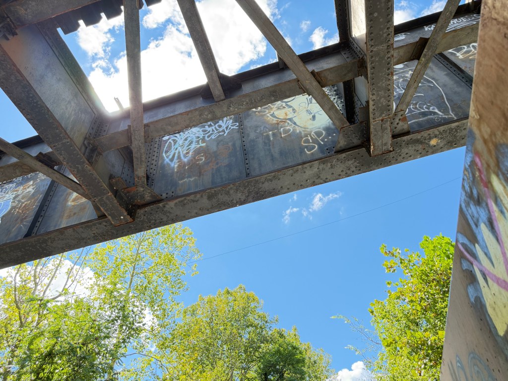 Graffiti tags on the underside of the railroad bridge
