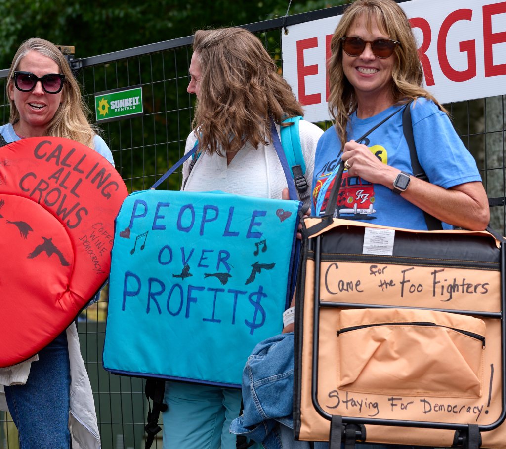Festivalgoers holding lettered seat cushions and a folding chair