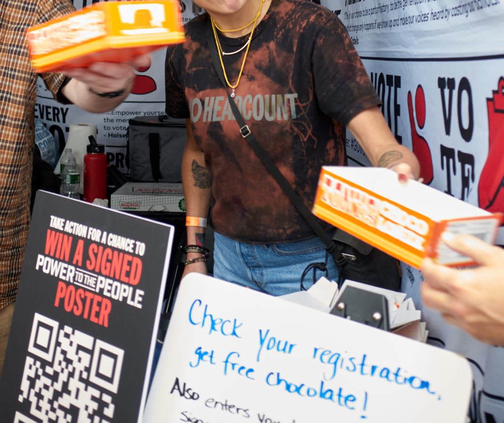 HeadCount worker handing out boxes of chocolate beside a hand-lettered sign