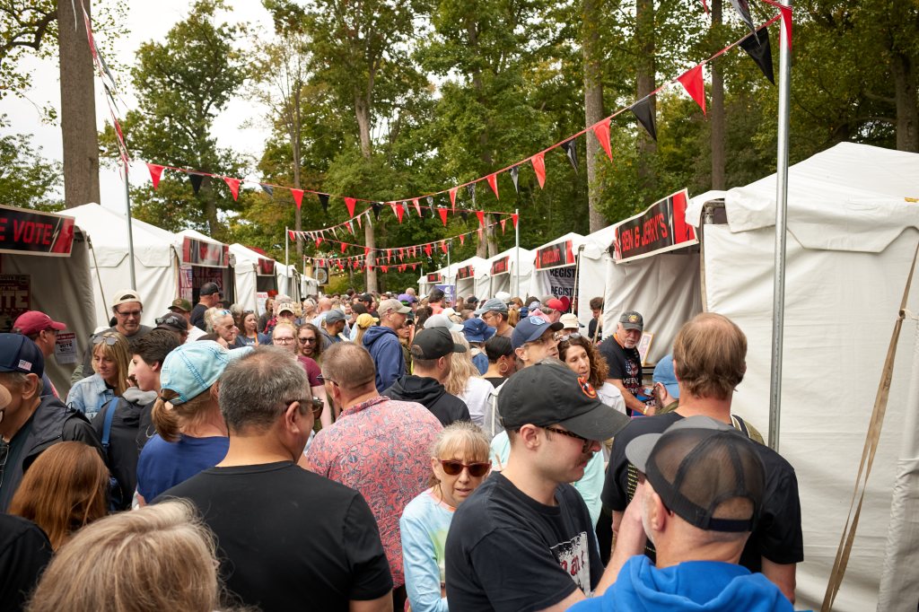 Crowded lane between white organization tents